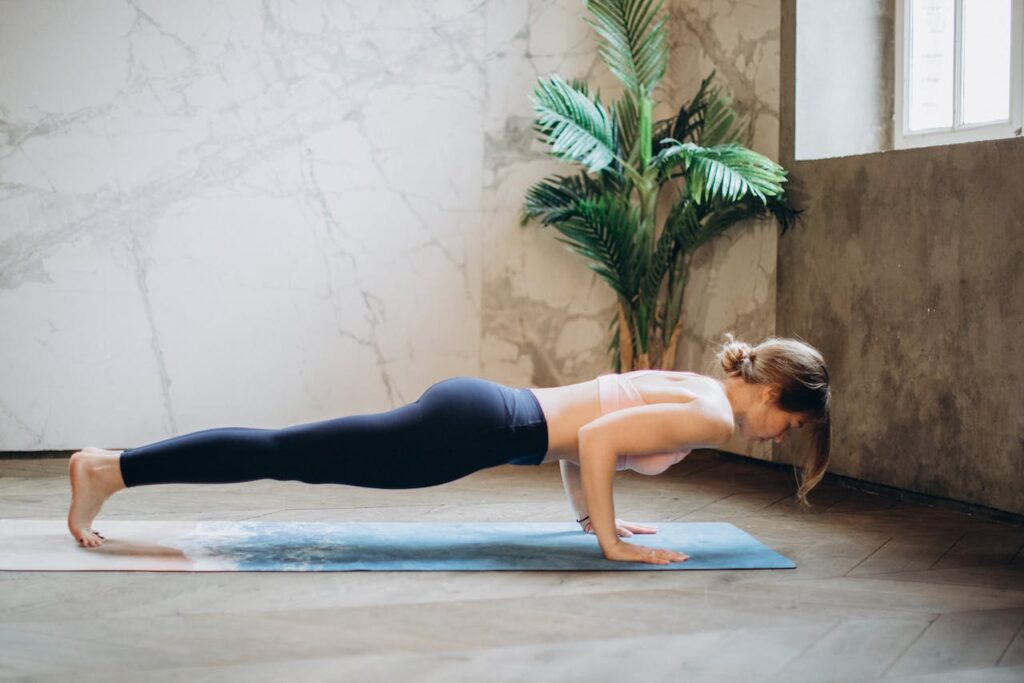 Junge Frau macht Plank-Übung als Ganzkörper-Stabilisationstraining